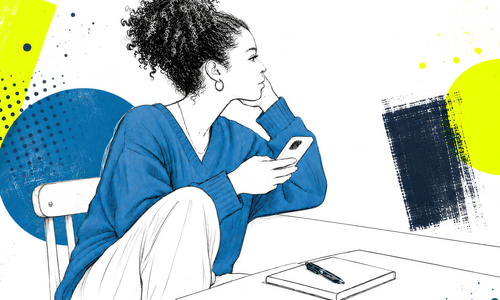 Eine junge Person sitzt an einem Tisch und hält ein Smartphone in der Hand.