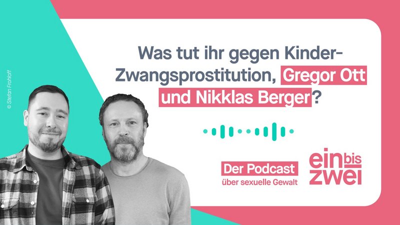 Schwarz-weiß-Aufnahme von zwei nebeneinander stehenden lächelnden Männern in legeren Oberteilen und drei-Tage-Bart