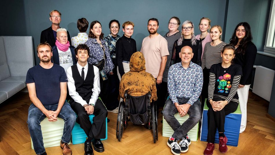 Group photo of the 17 members of Survivors’ Board at UBSKM, sitting and standing at regular intervals and looking at the camera, with two people standing with their backs to the camera.