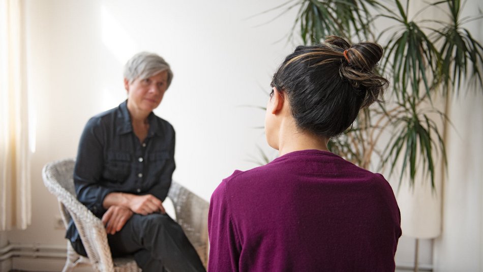 UBSKM Hilfethemen // Motiv 5 Zwei Frauen sitzen in einer Therapiesitzung gegenüber und sprechen miteinander