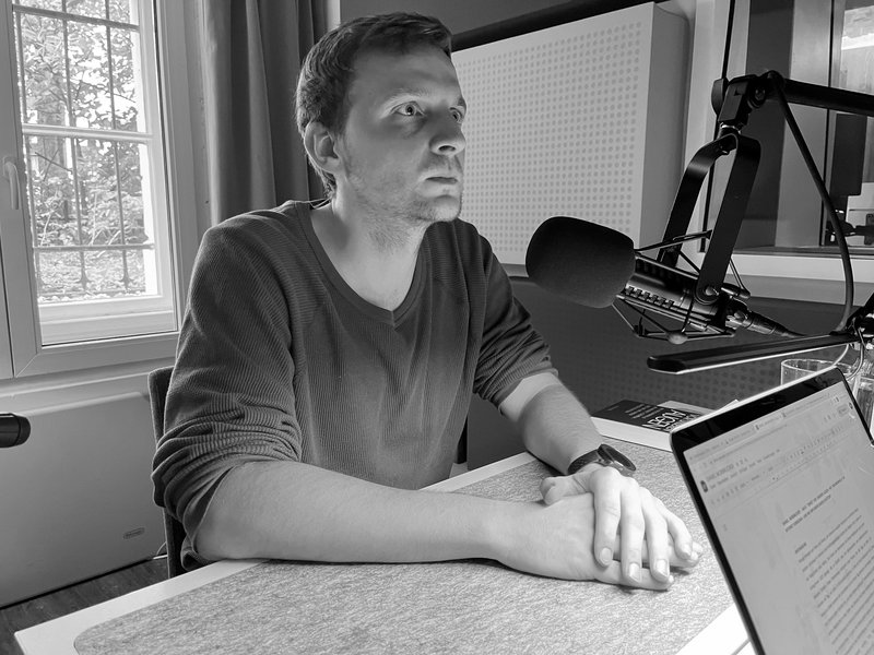 Daniel Mossbrucker bei der Aufnahme des Podcasts vor einem Mikrophone